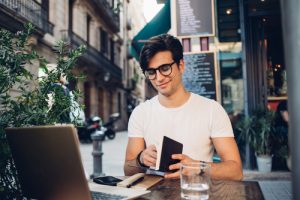 man completes tax deadline taxes working at café